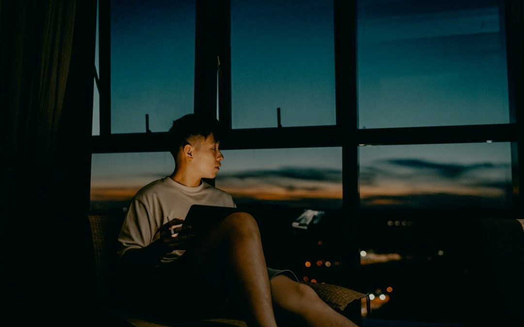 Persona pensativa junto a la ventana durante una noche de insomnio