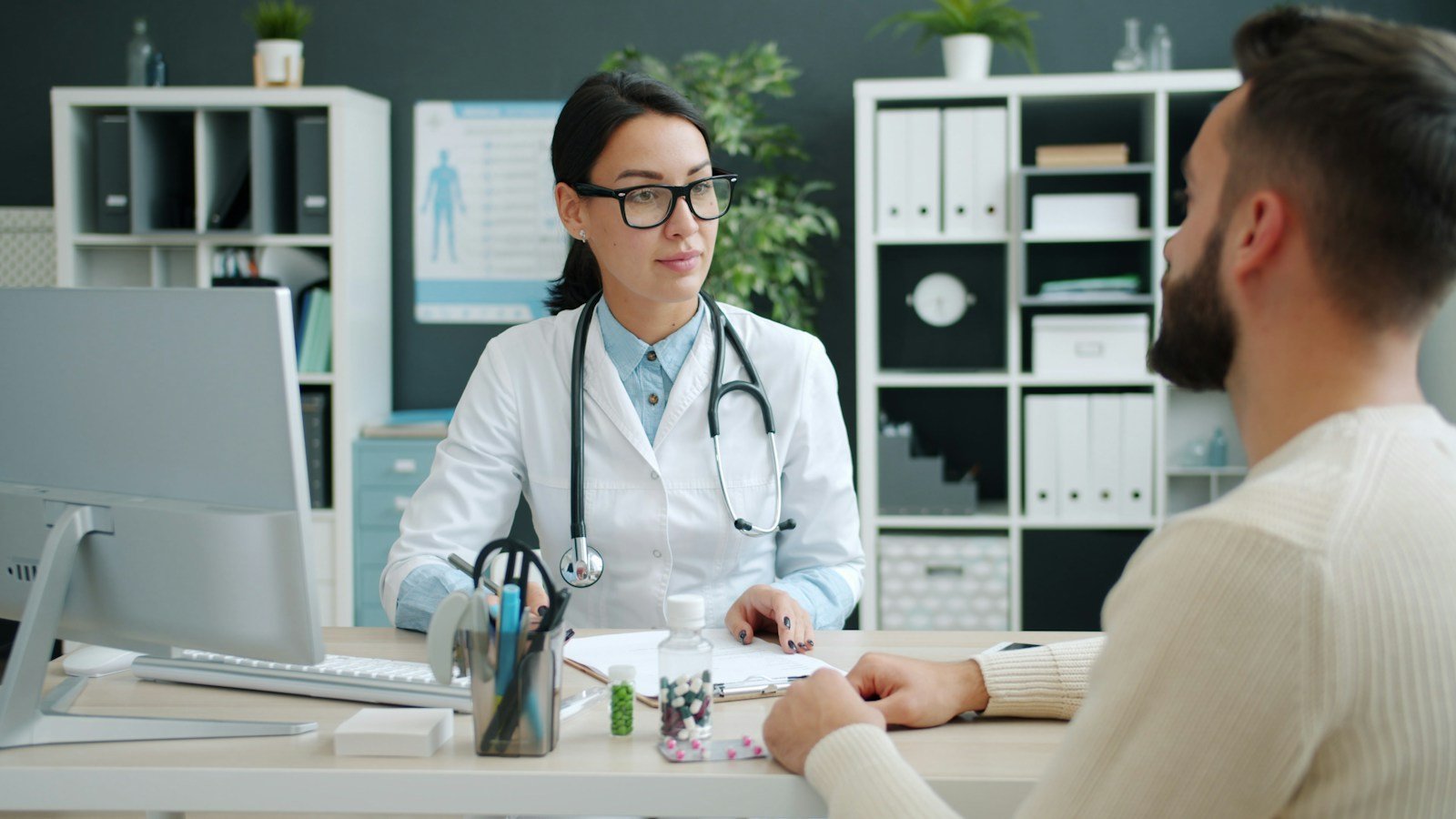 Profesional sanitario atendiendo a un paciente joven en consulta médica