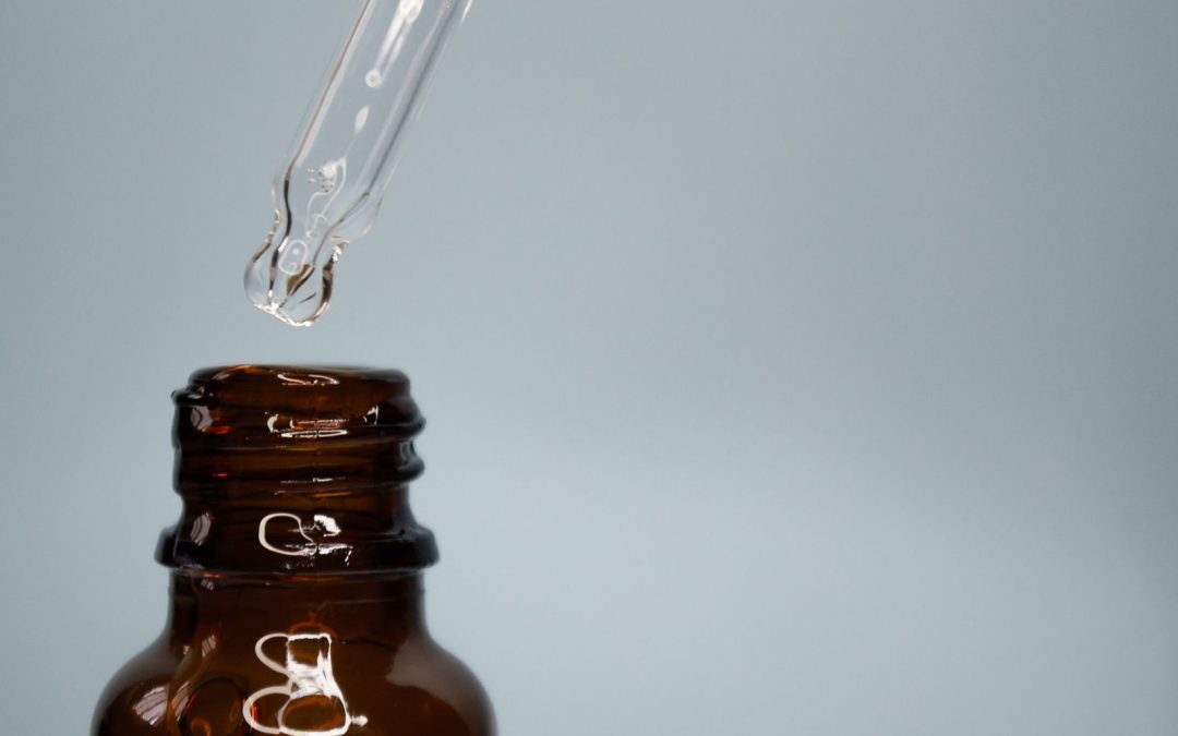 Frasco de cristal oscuro con nitritos de alquilo sobre superficie neutra